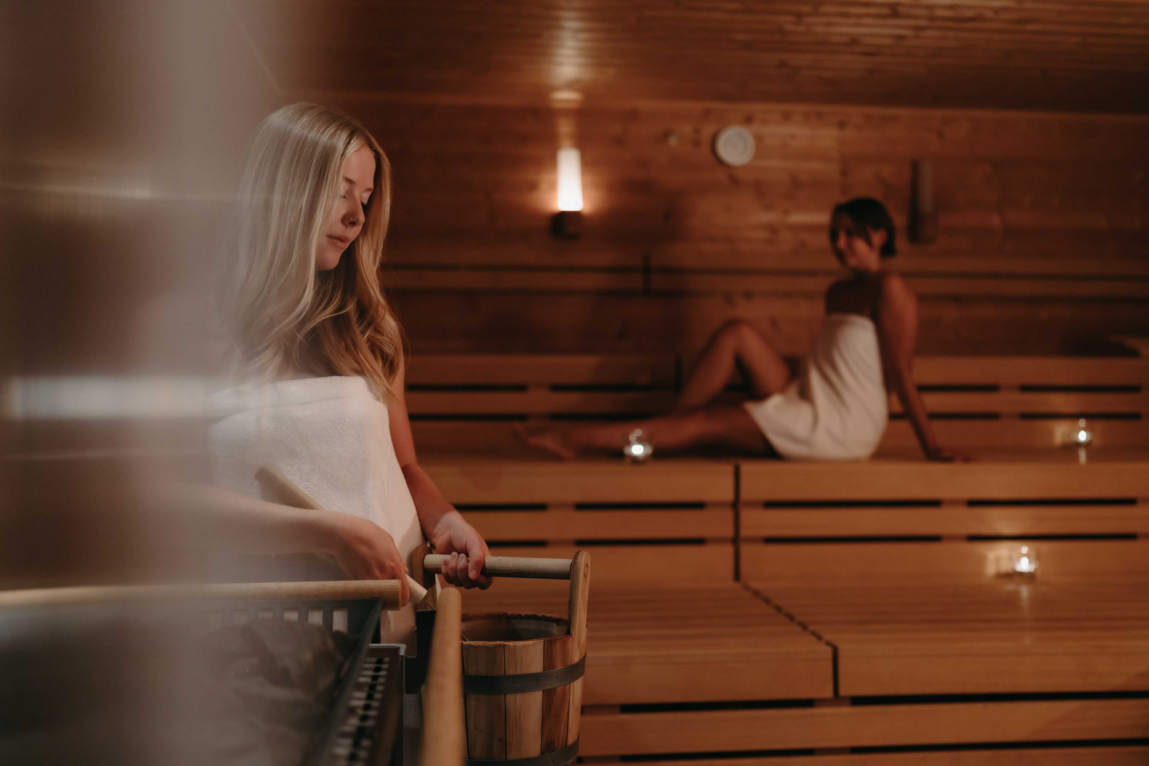 Adding water to the hot stones in the sauna