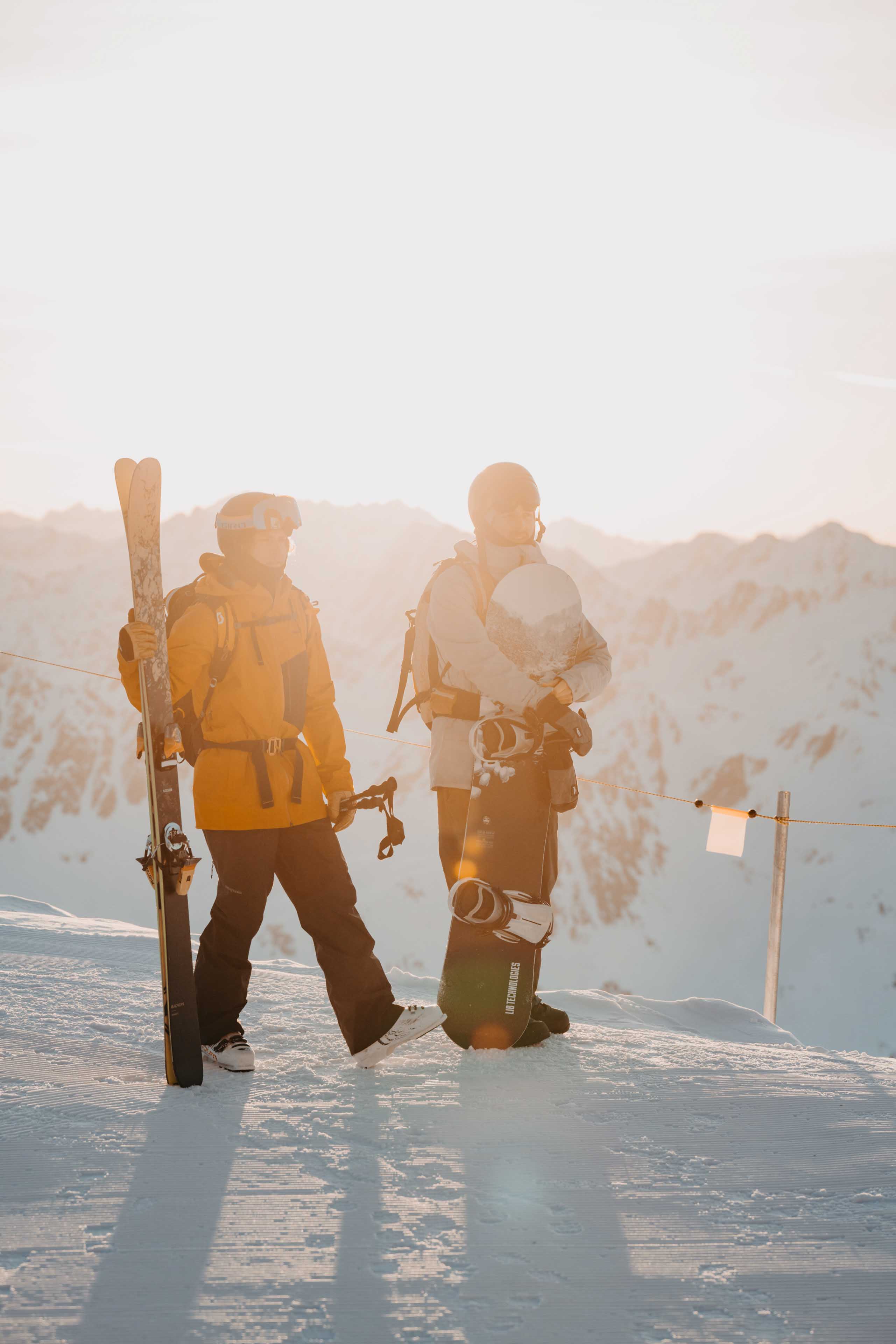 Skier and snowboarder in the morning light