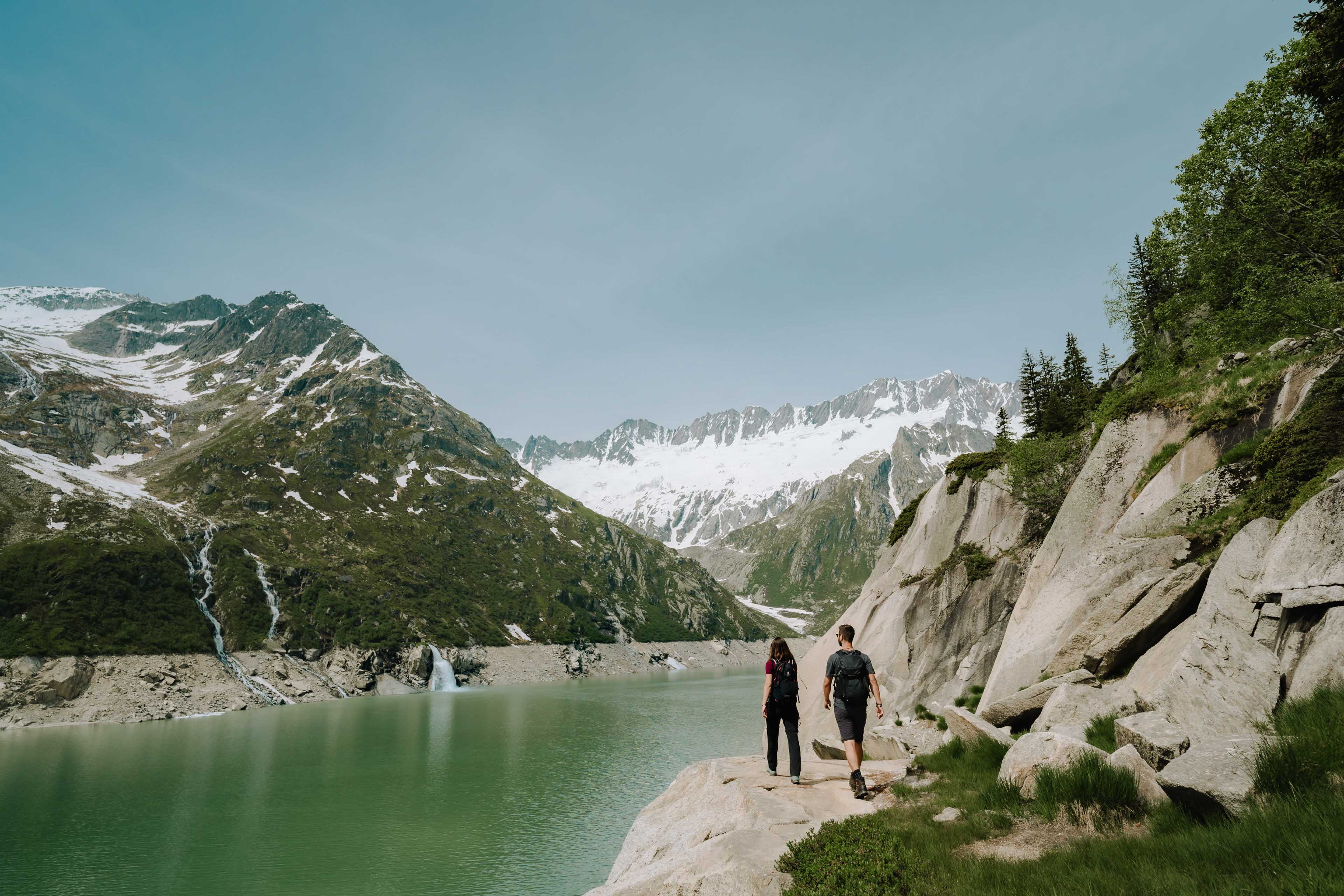 Two hikers at a mountain lake in the alps