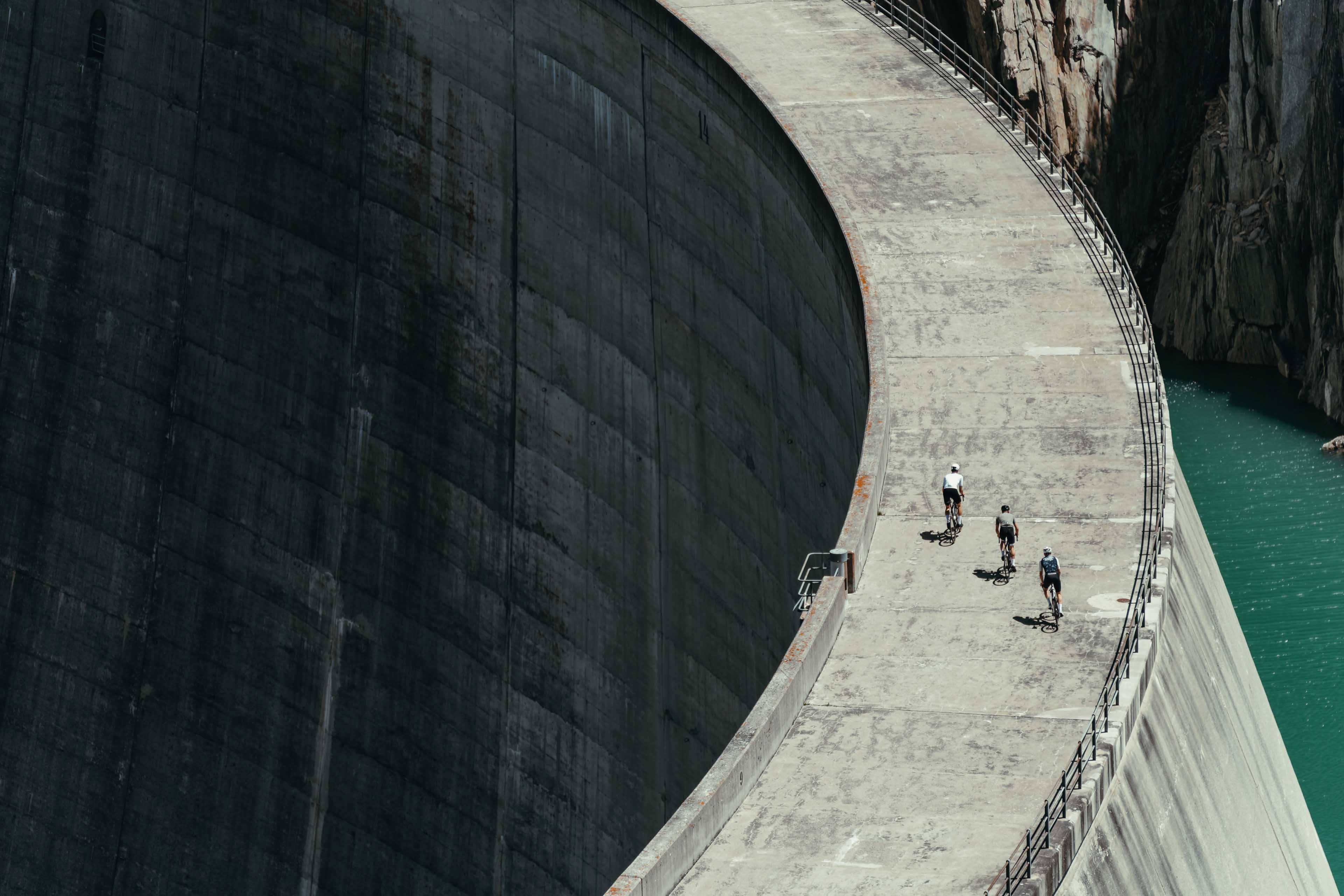 Cyclists on a reservoir dam in the alps, Switzerland